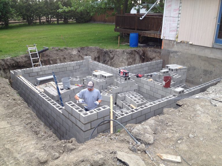 Mason Builds Corner in New Block Foundation
